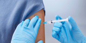 Imagem ilustrativa mostra sala de vacinação com profissional aplicando vacina da gripe para divulgar ampliação da campanha de vacinação contra gripe em Indaiatuba