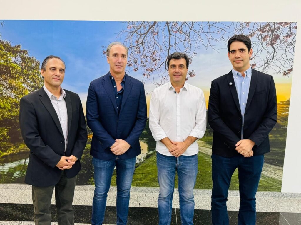 Na foto colorida da esquerda para a direita estão Marcelo Rodrigues, Júnior Tonin, o prefeito Dr. Custódio Tavares e Alexandre Fontes. Todos estão em pé, posando para a foto. Ao fundo uma parede com uma foto colorida de um trecho do Parque Ecológico